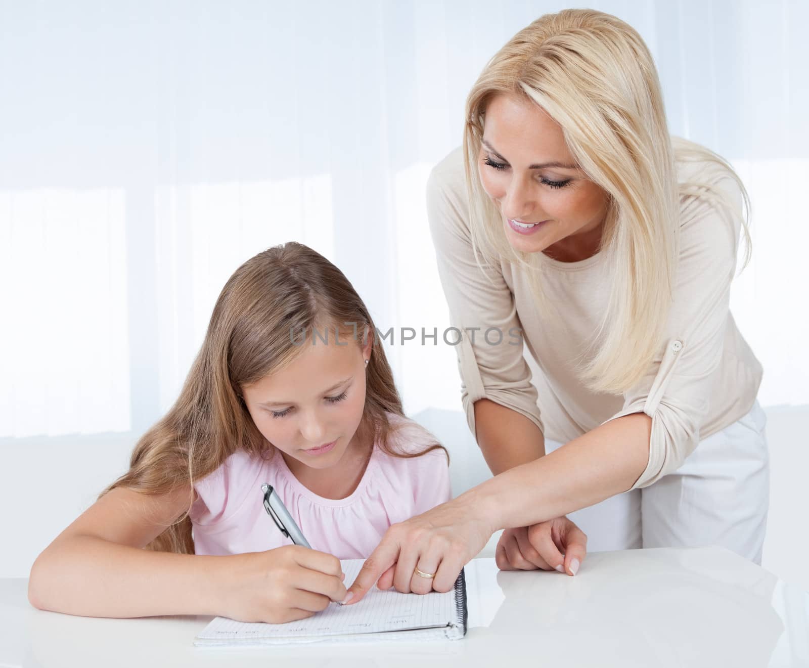 Mother Helping Her Daughter With Homework At Home