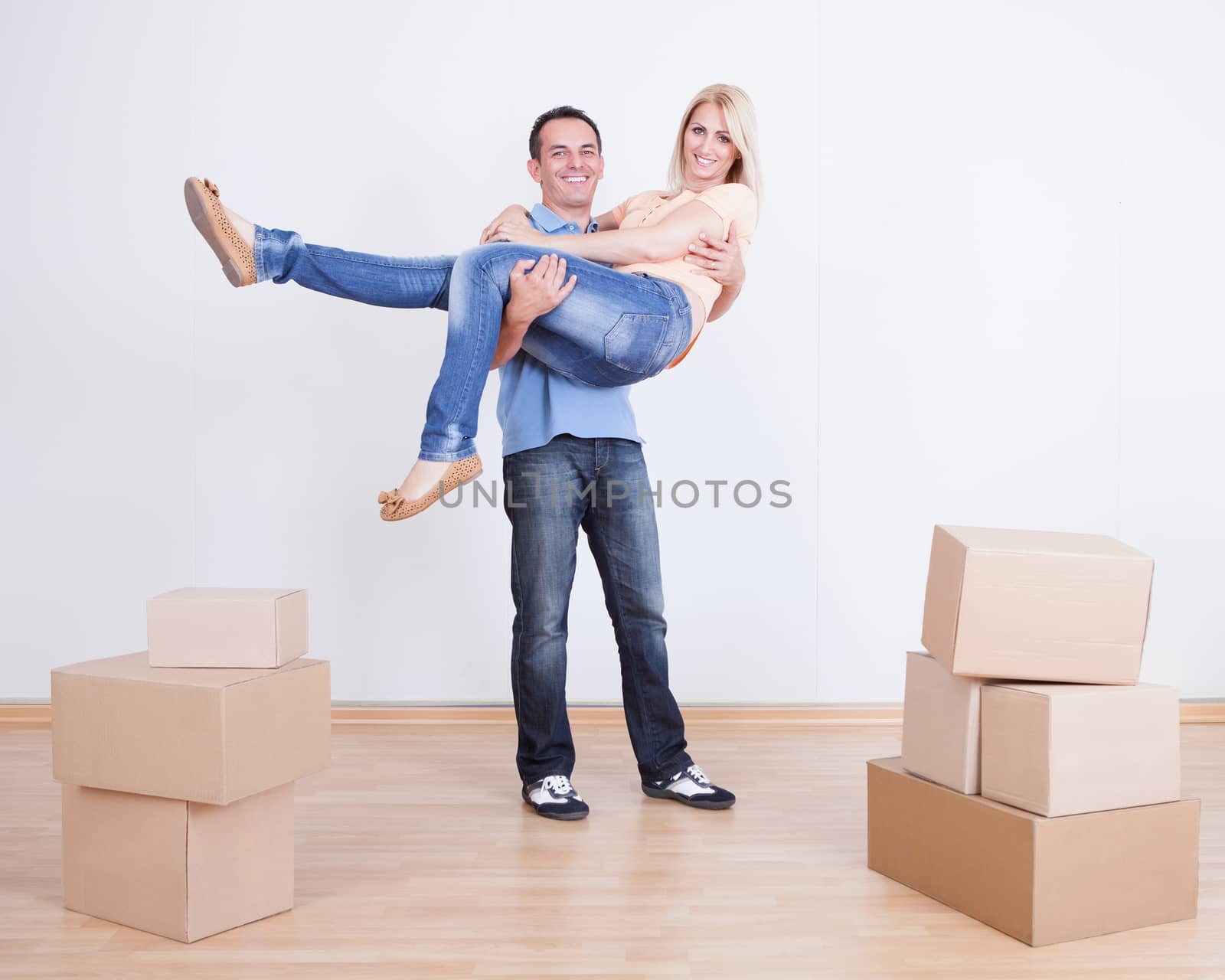 Portrait Of Husband Holding Wife In New Home, Indoors