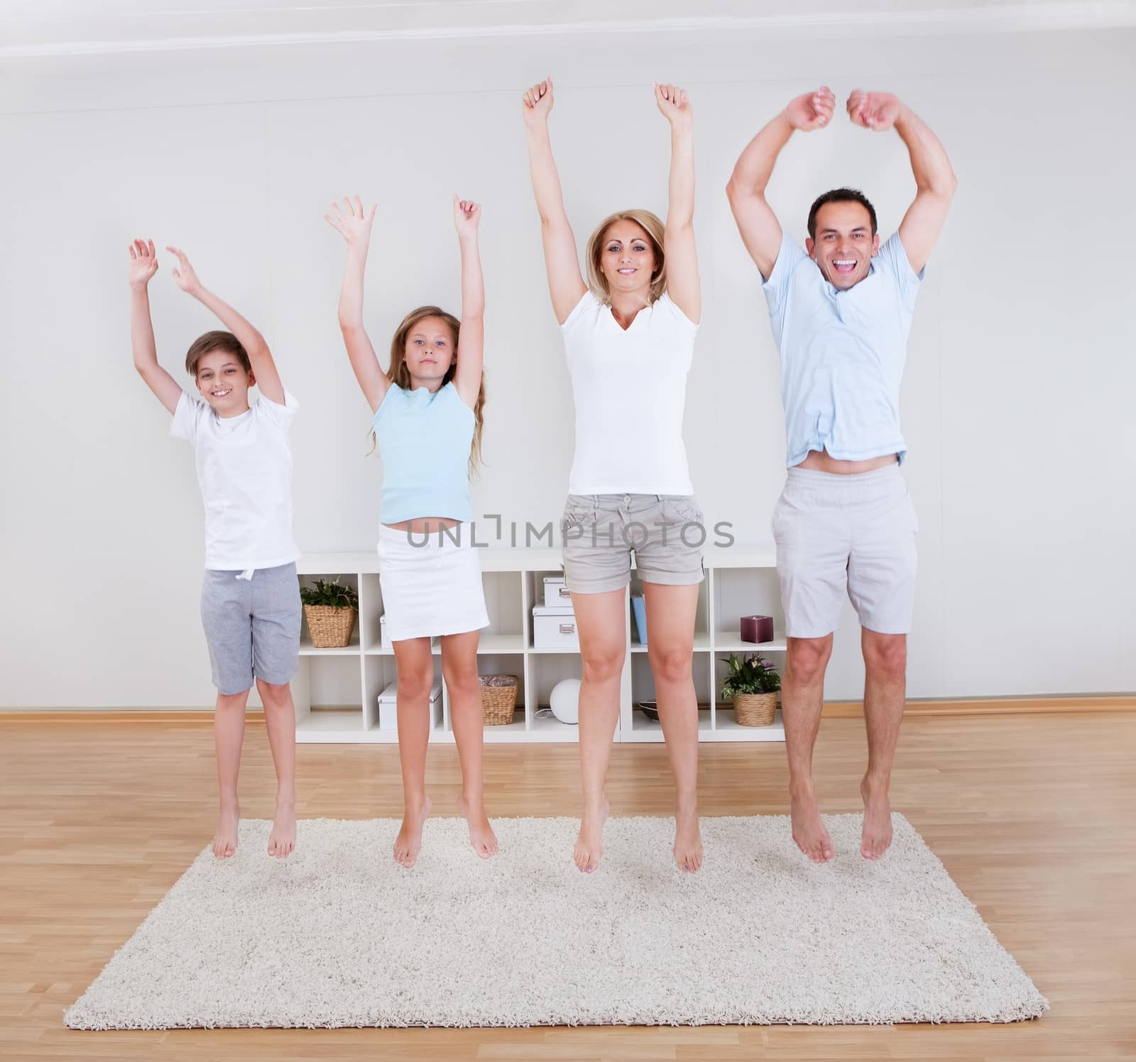 Family Doing Stretching Exercises On The Carpet by AndreyPopov