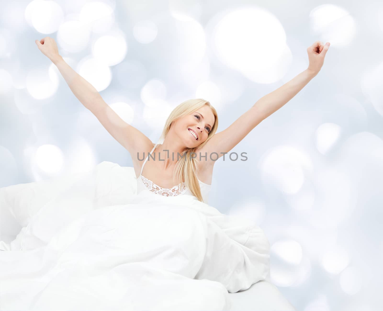 Young happy smiling woman waking up at bedroom