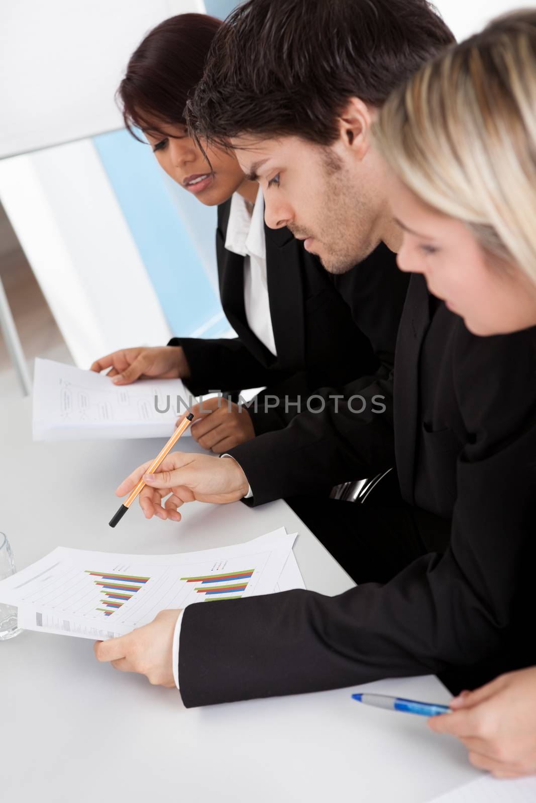 Group of business people looking at charts by AndreyPopov