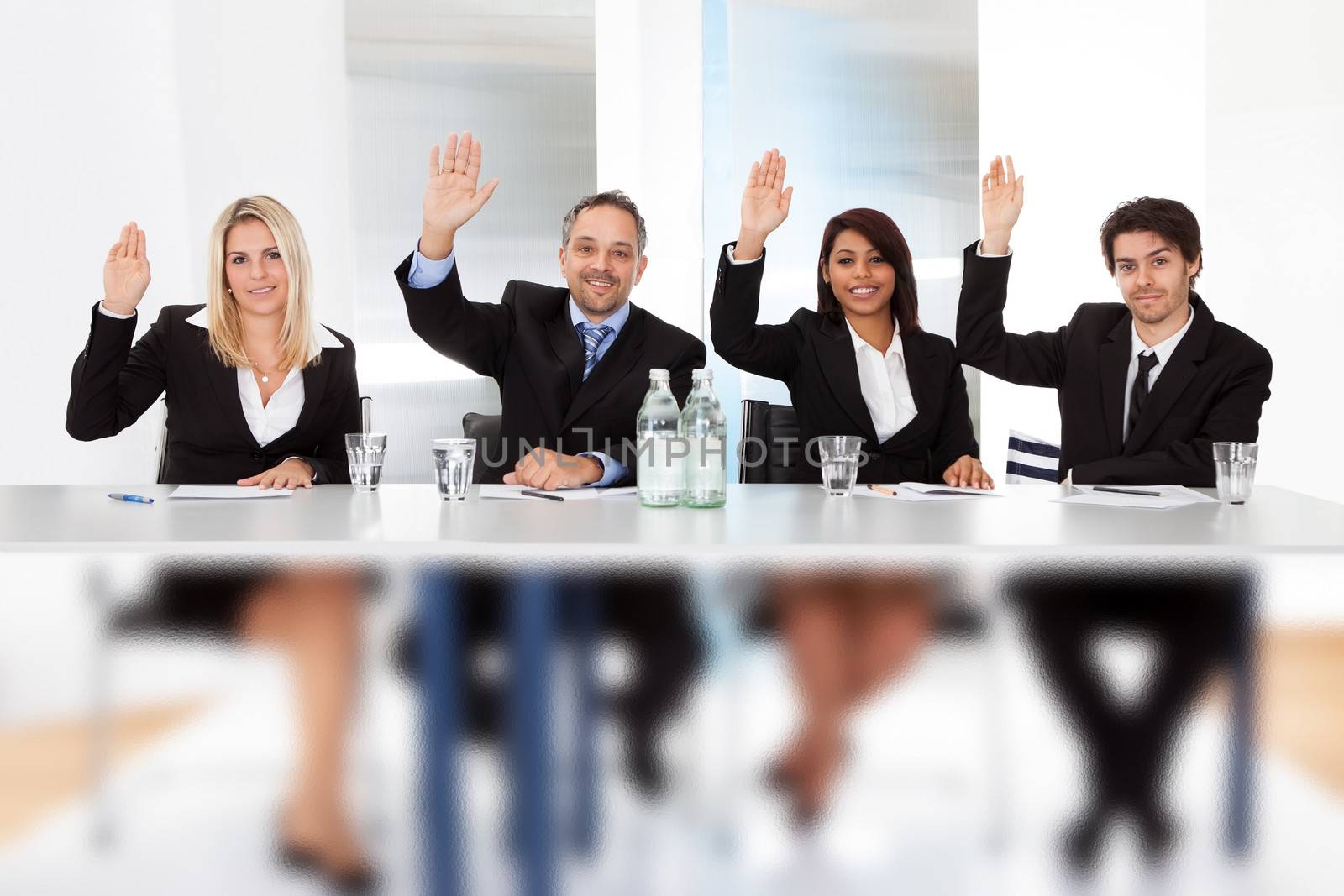 Group of business people voting at the meeting