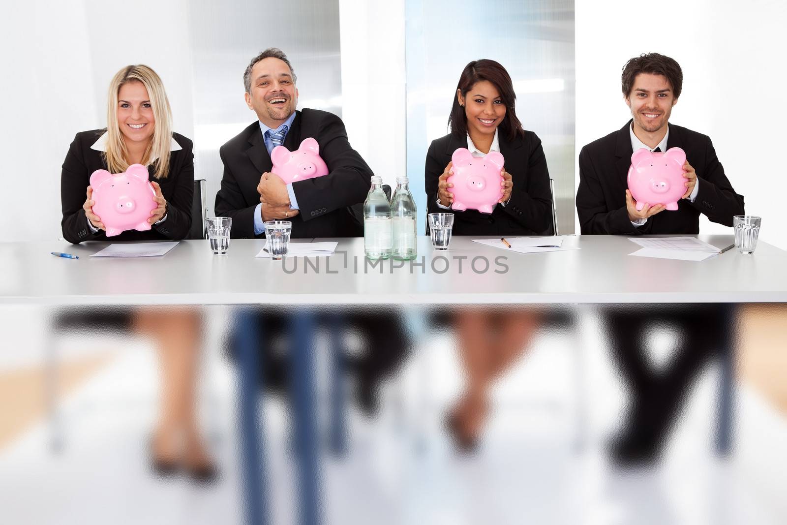 Business people holding piggy banks by AndreyPopov