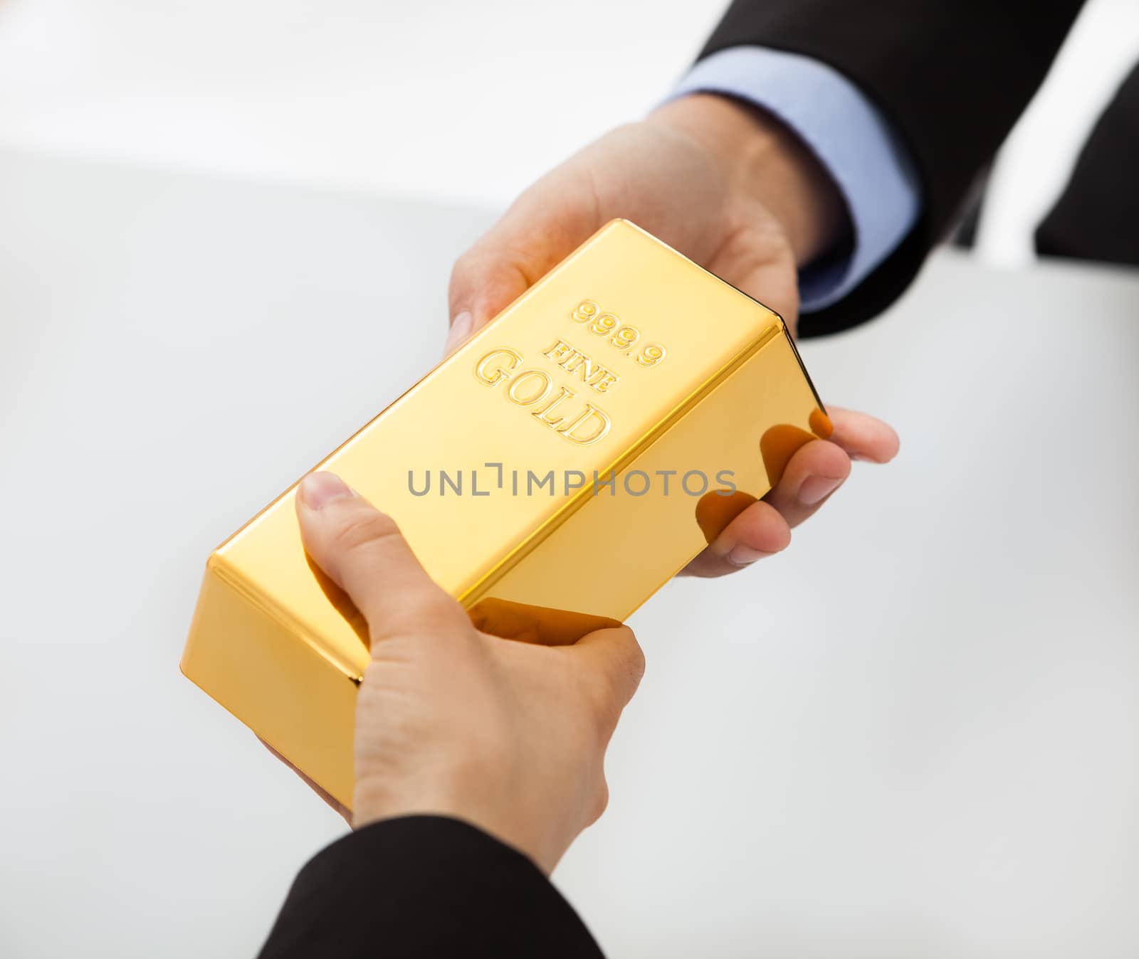 Business people exchanging golden bar by AndreyPopov