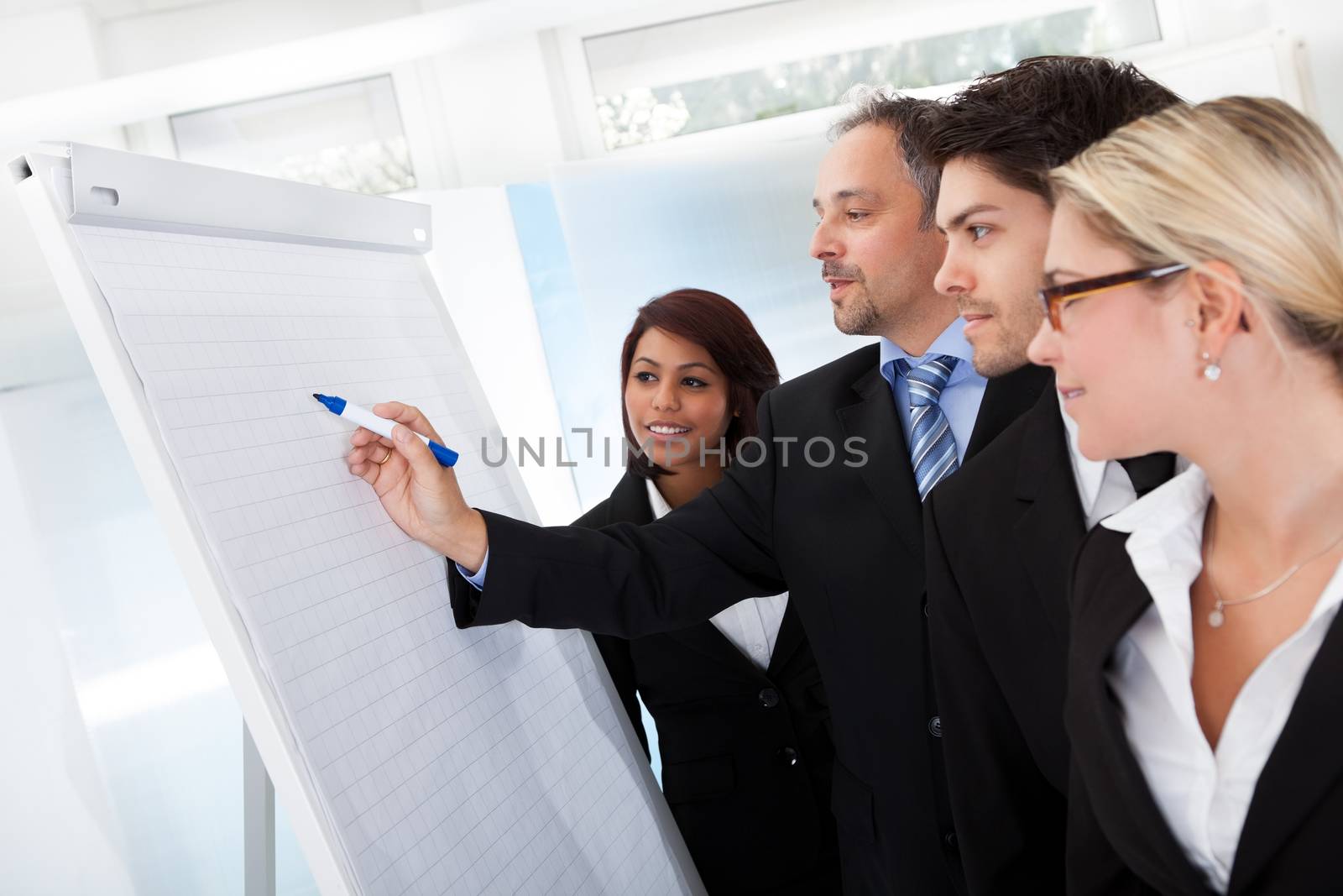 Group of business people looking at the graph on flipchart