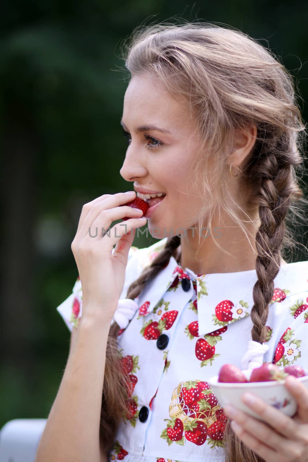 Portrait of the beautiful girl with a strawberry