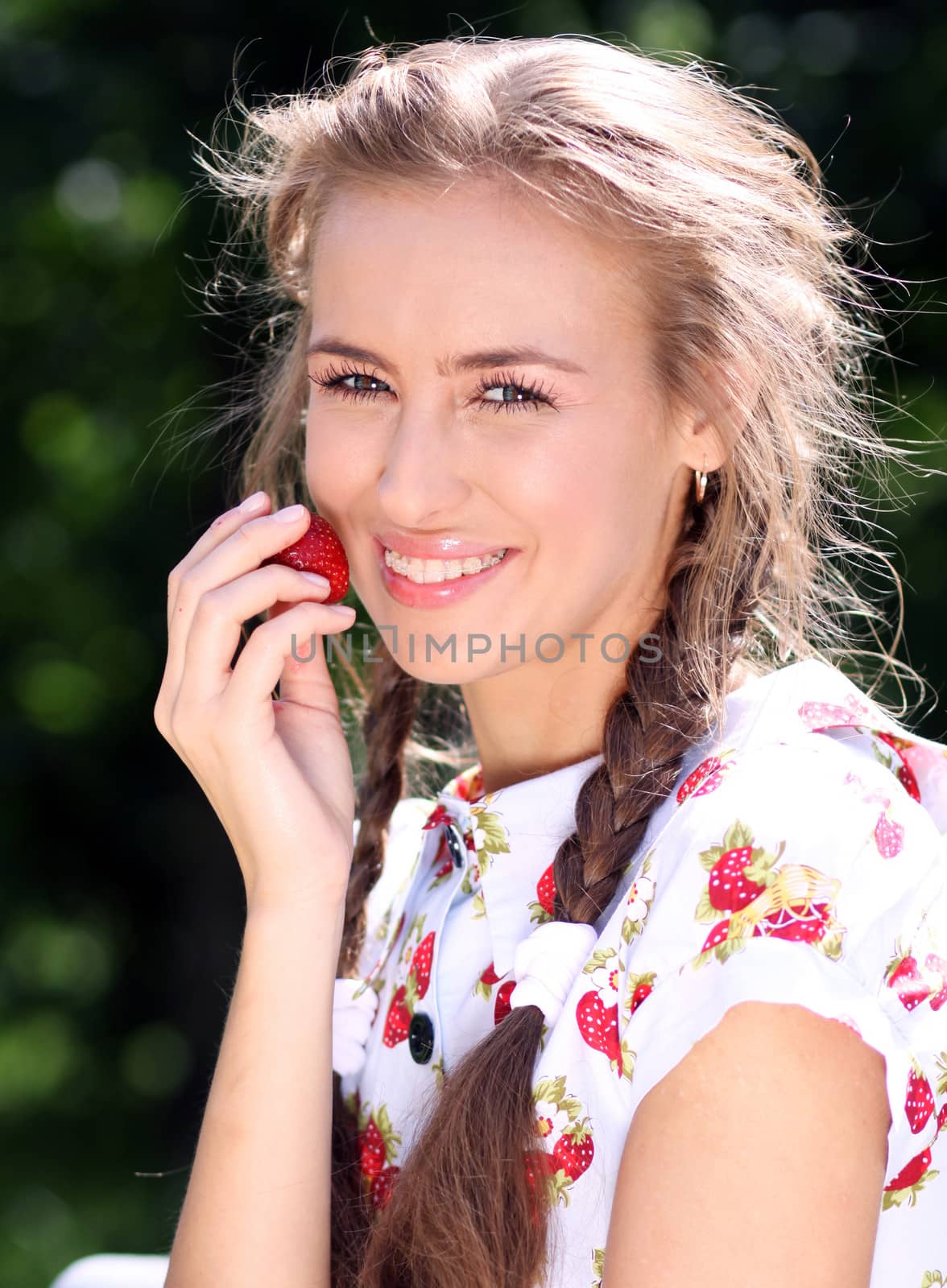 Portrait of the beautiful girl with a strawberry