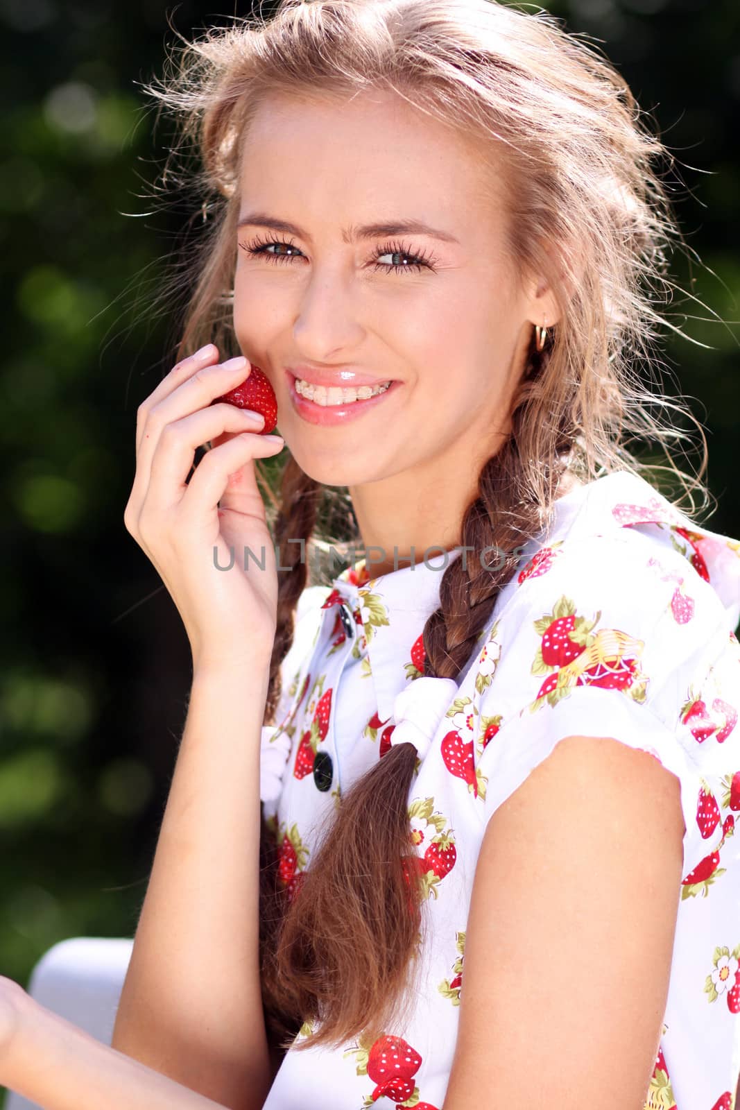 Portrait of the beautiful girl with a strawberry