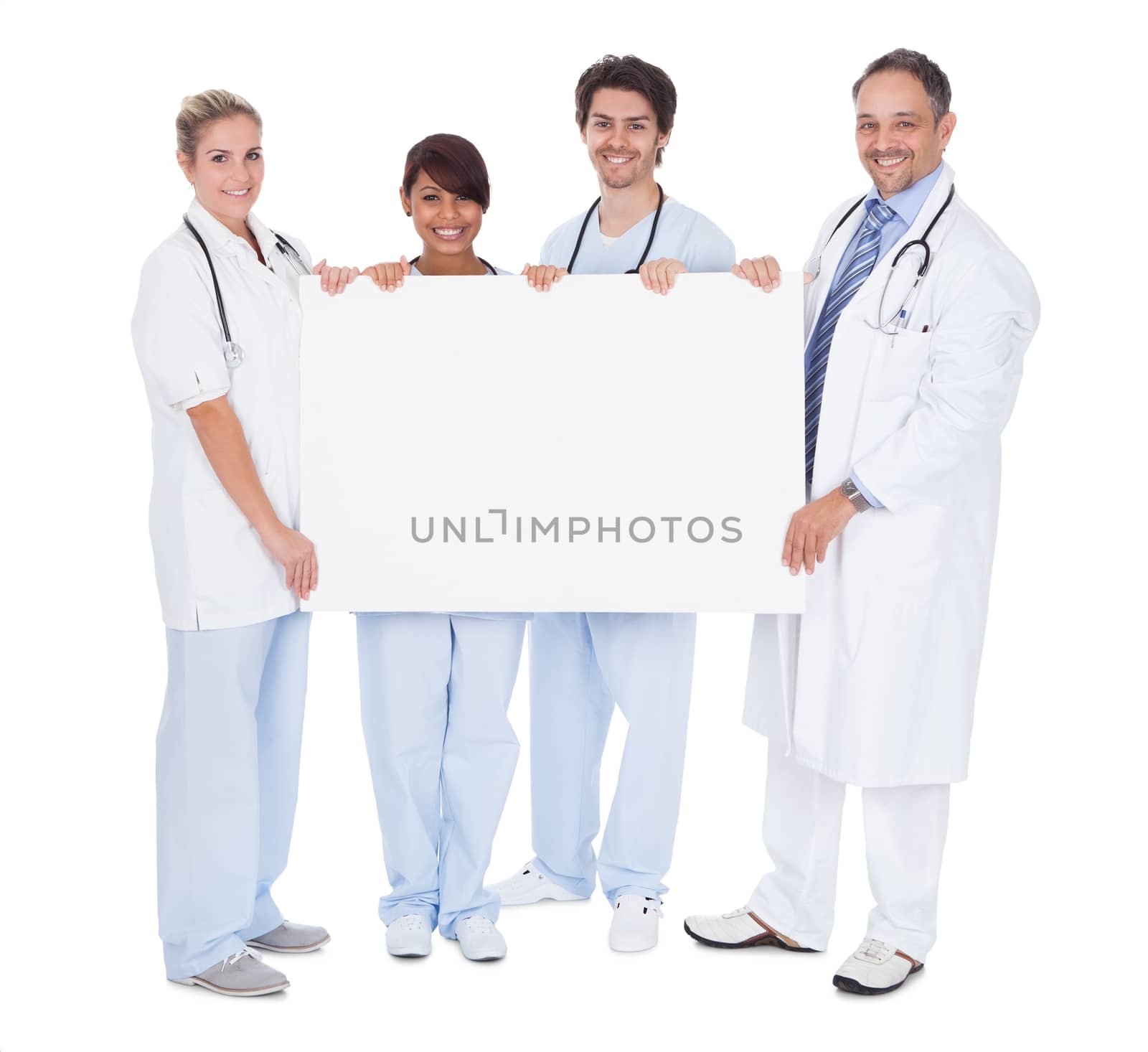 Group of doctors presenting empty board. Isolated on white