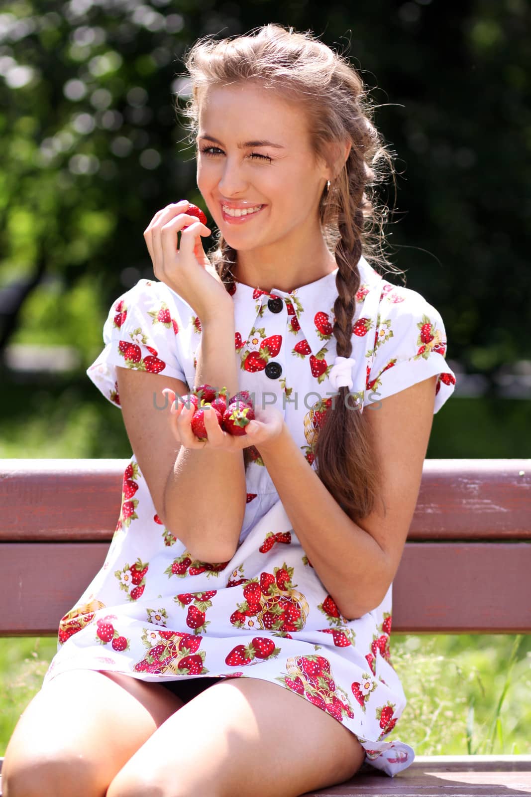 Portrait of the beautiful girl with a strawberry