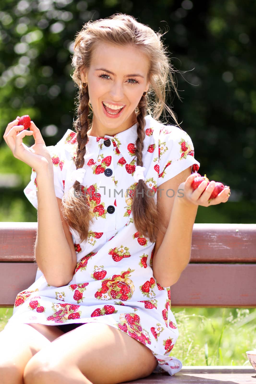 Portrait of the beautiful girl with a strawberry
