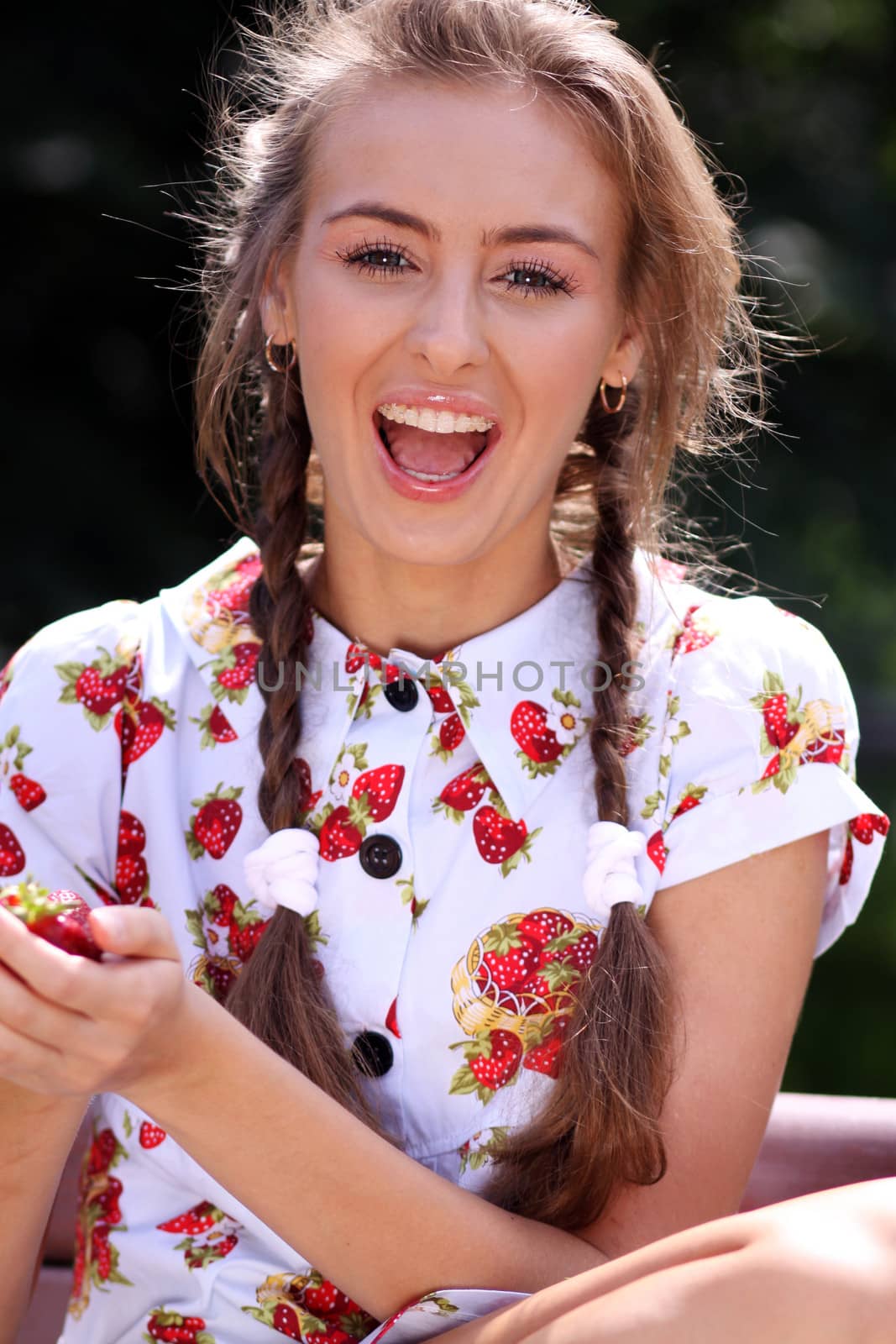Portrait of the beautiful girl with a strawberry