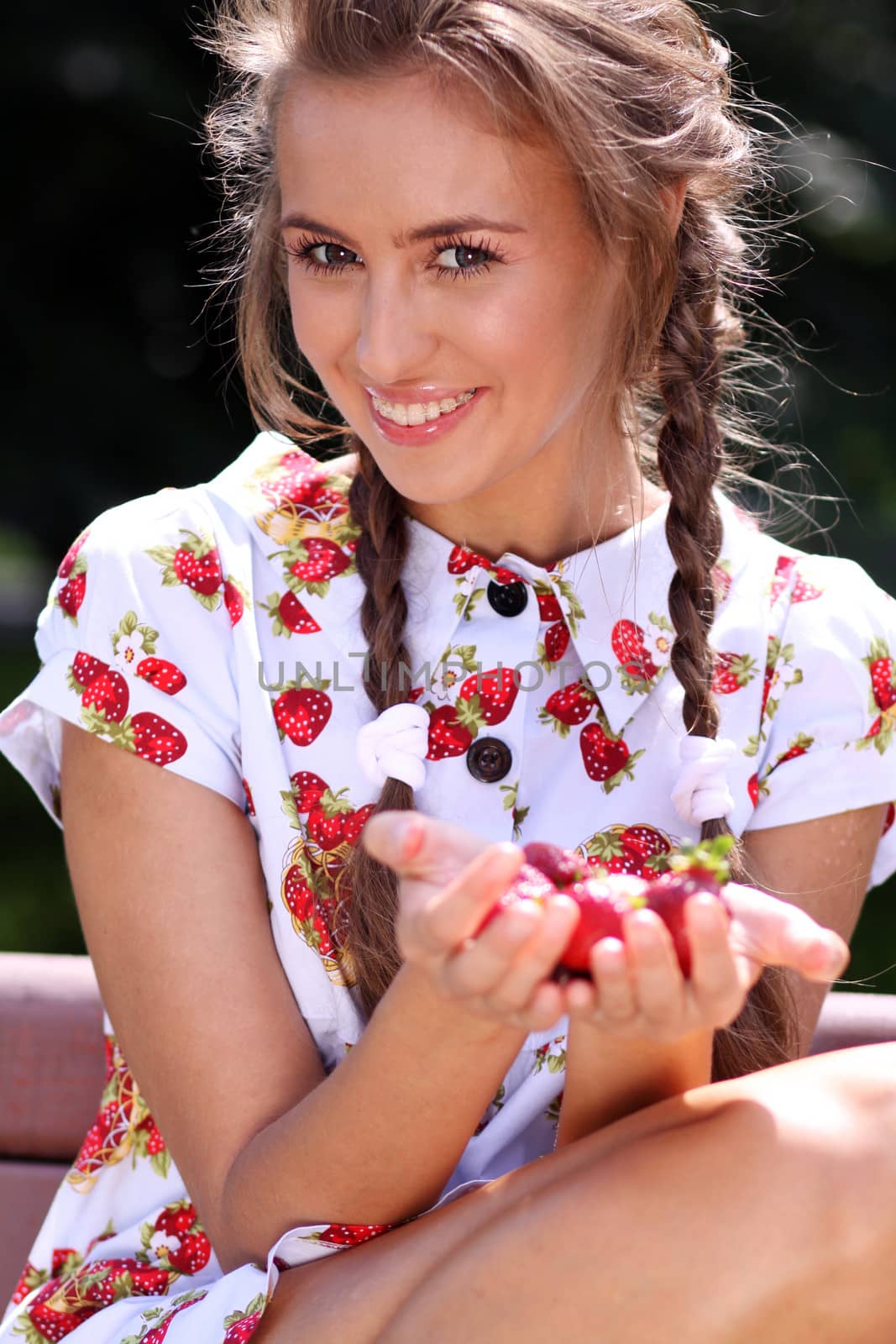 Portrait of the beautiful girl with a strawberry