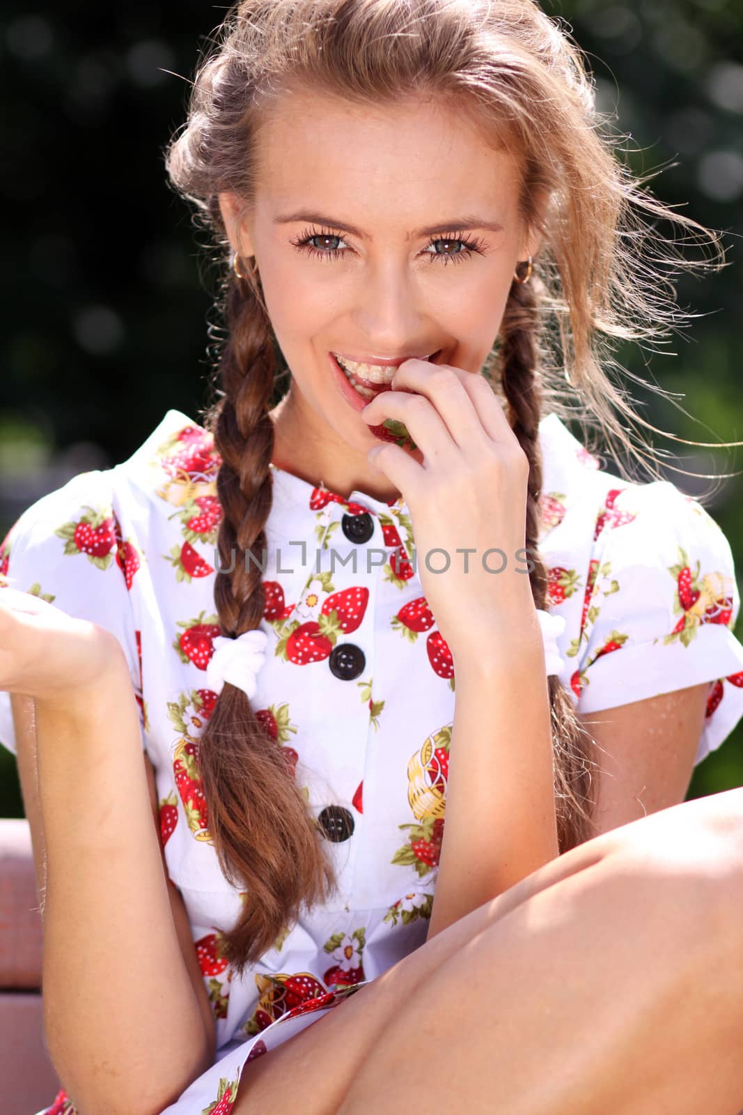 Portrait of the beautiful girl with a strawberry