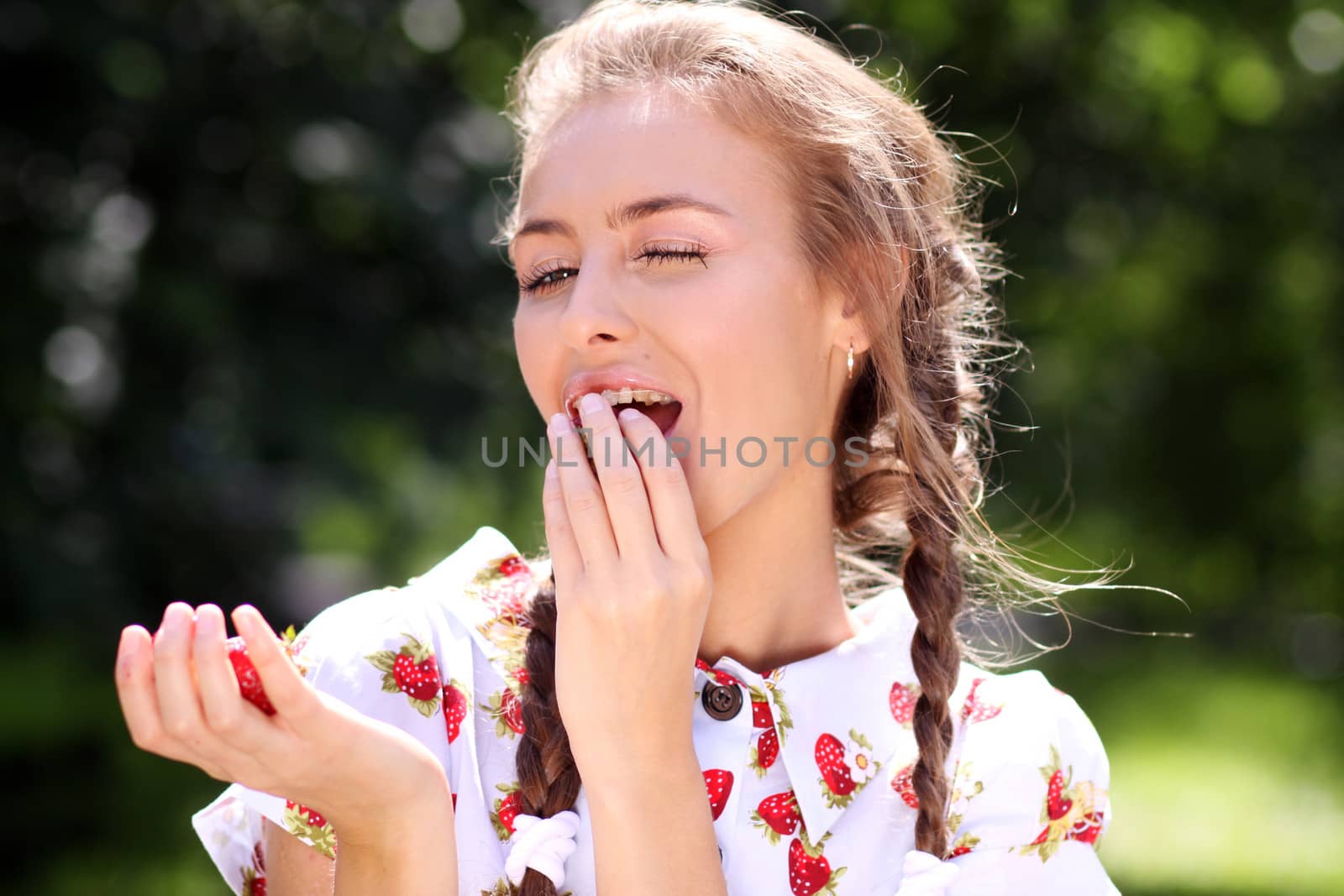 Portrait of the beautiful girl with a strawberry