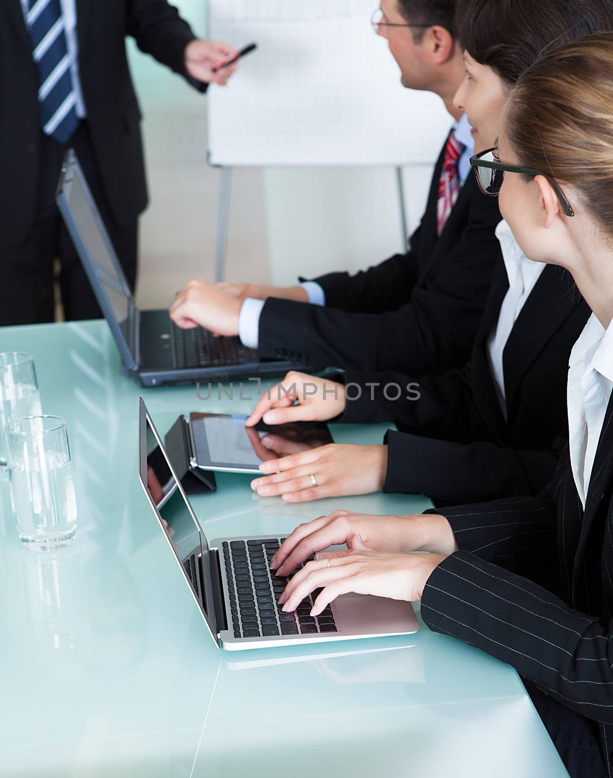 Businesspeople working on laptops and tablets by AndreyPopov