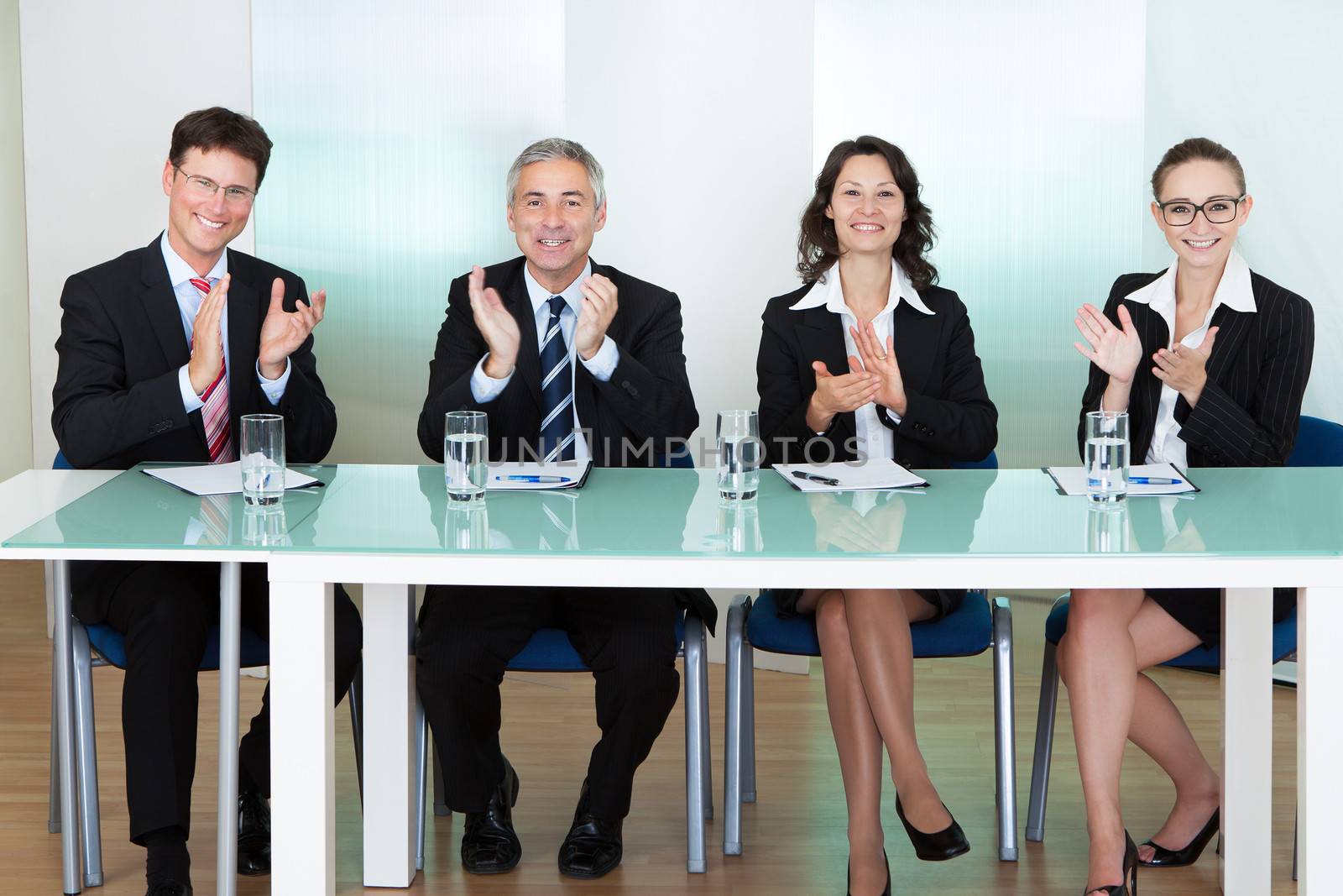 Group of corporate recruitment officers interviewing for a professional vacancy applauding