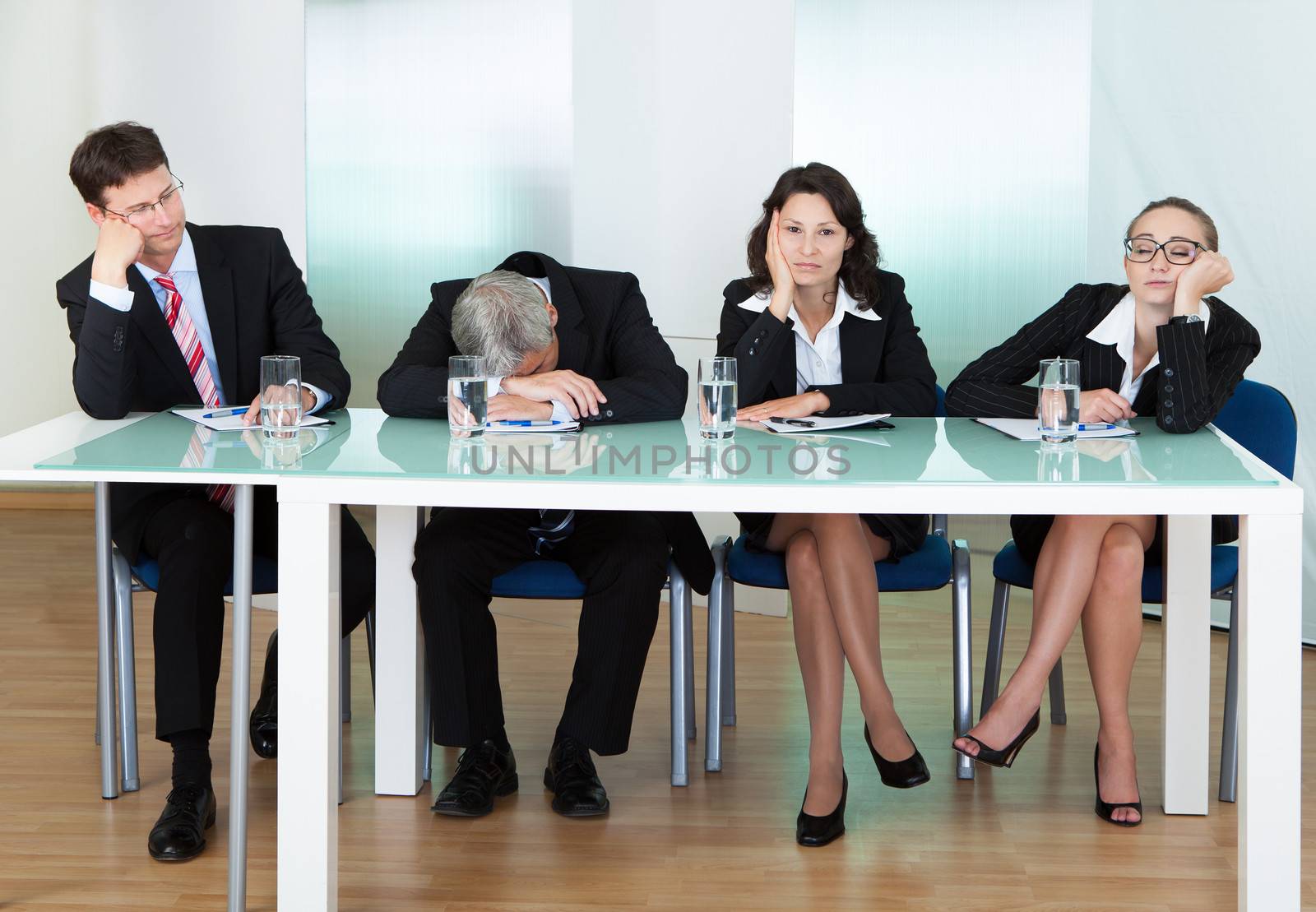 Bored panel of professional judges or corporate interviewers lounging around on a table napping as they wait for something to happen