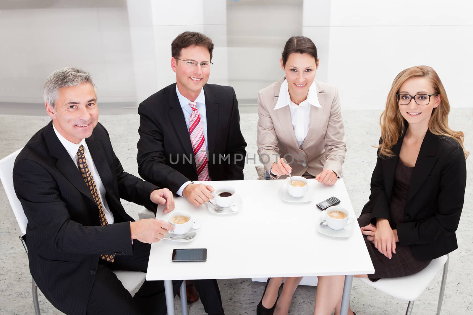 Business executives enjoying coffee by AndreyPopov