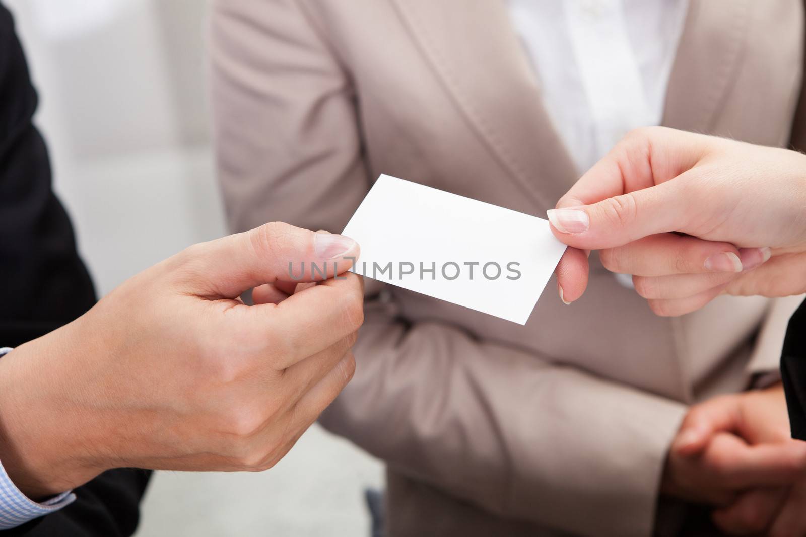 Businesspeople exchanging cards over coffee by AndreyPopov