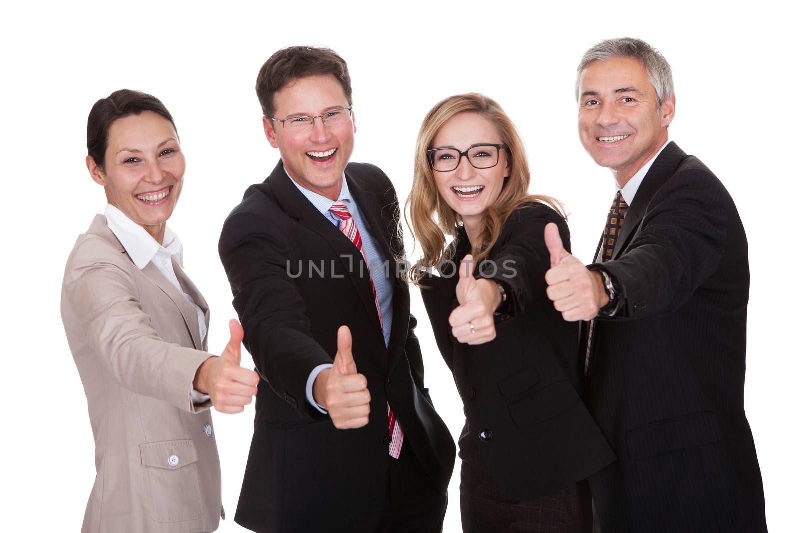 Laughing group of business executives giving a thumbs up of approval and victory as they celebrate a successful outcome isolated on white