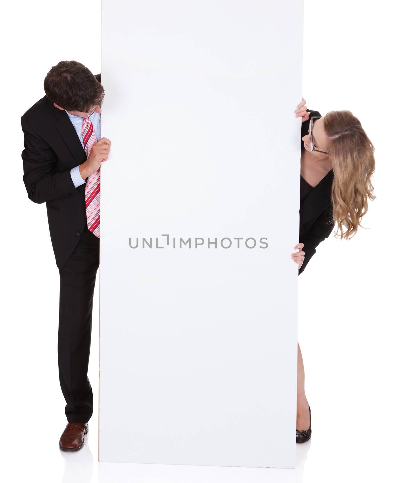 Smiling professional man and woman wearing glasses holding up a blank white sign for your text or advertisement isolated on white