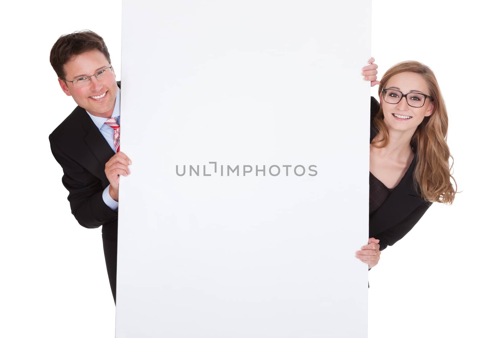 Smiling professional man and woman wearing glasses holding up a blank white sign for your text or advertisement isolated on white