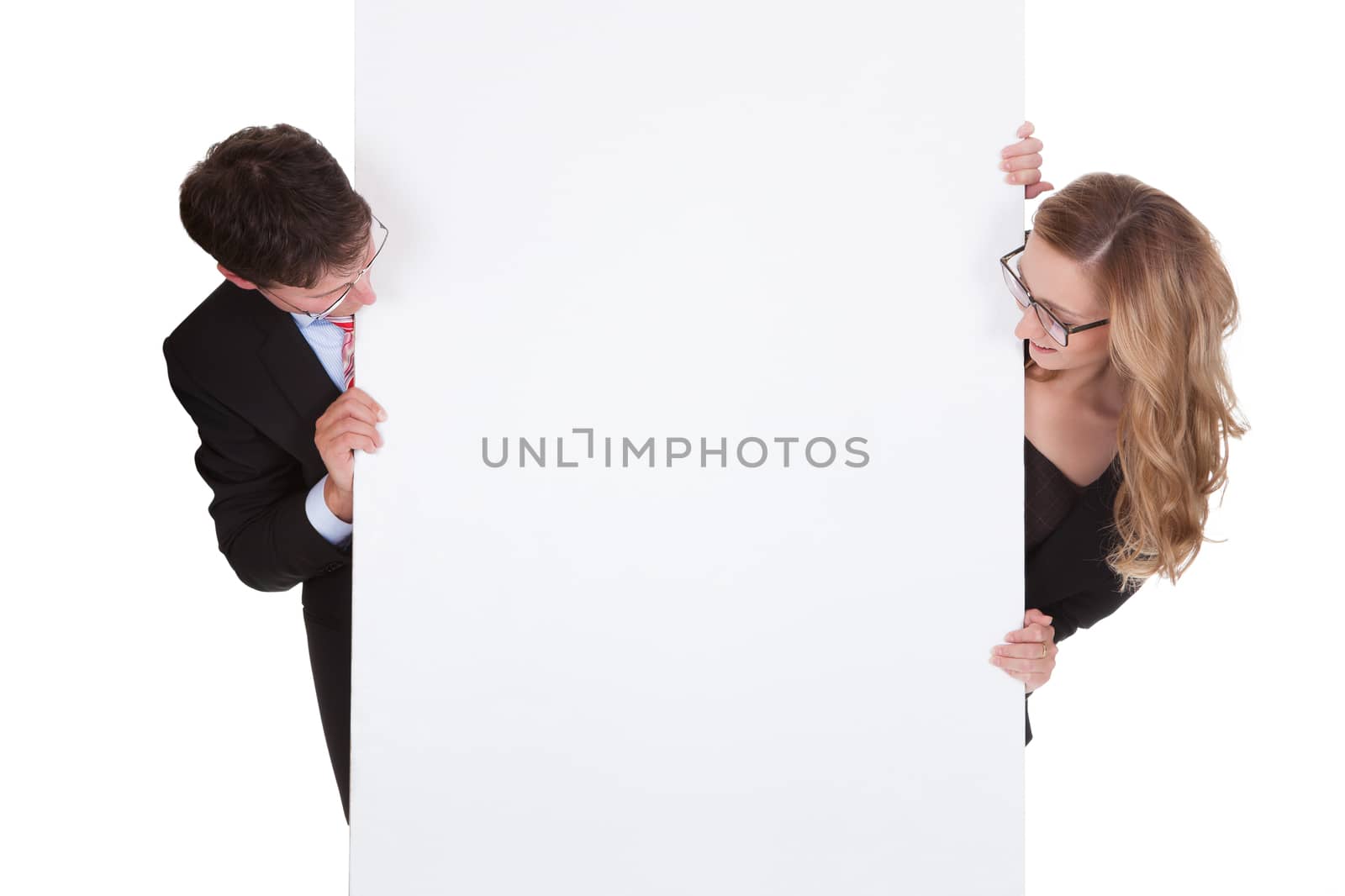 Smiling professional man and woman wearing glasses holding up a blank white sign for your text or advertisement isolated on white