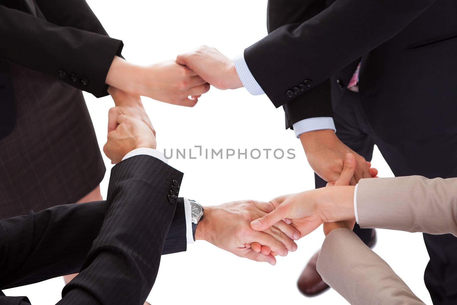 Cropped overhead view of a diverse group of businesspeople linking hands in a team