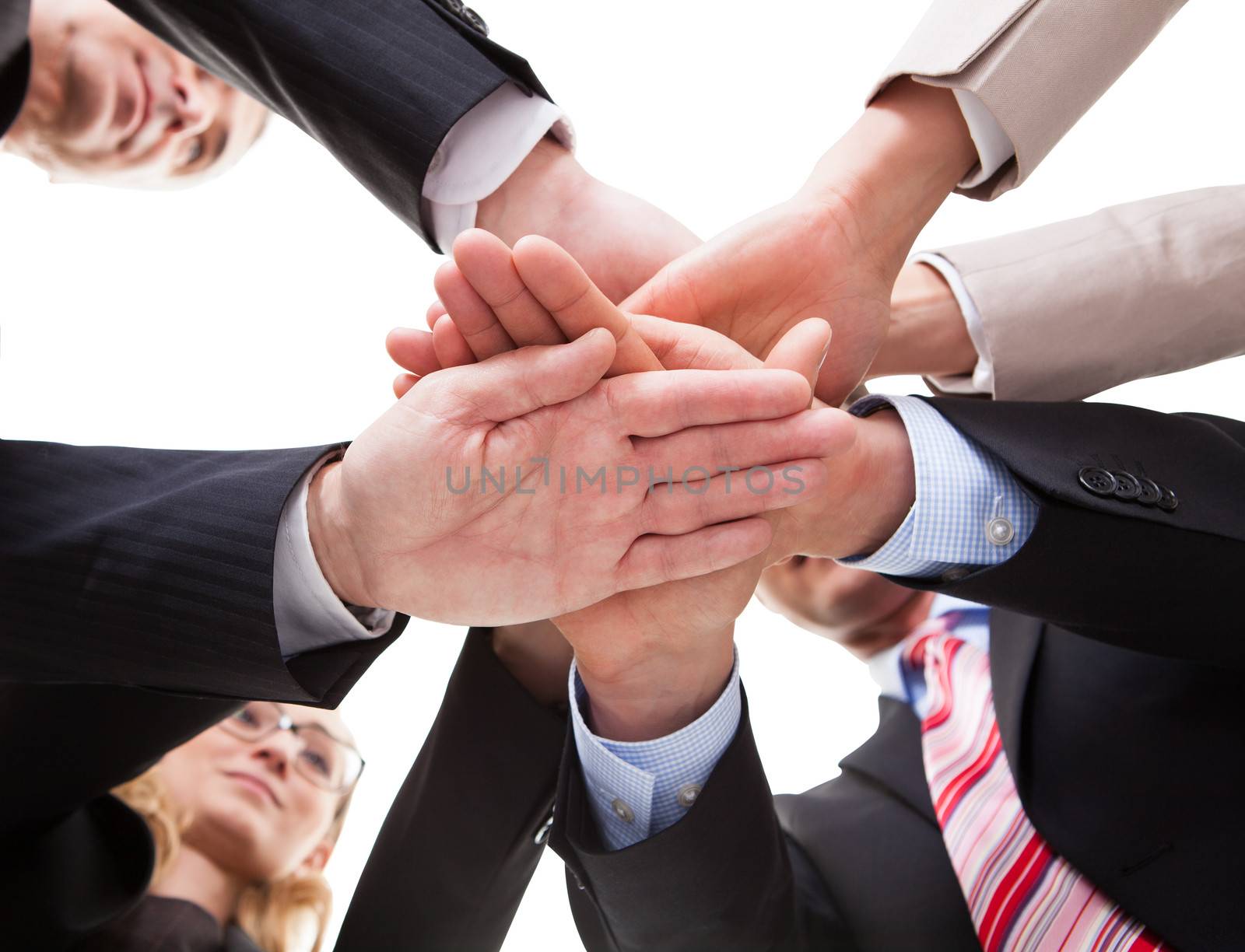 View from underneath of a group of businesspeople standing in a circle placing their hands on top of each other