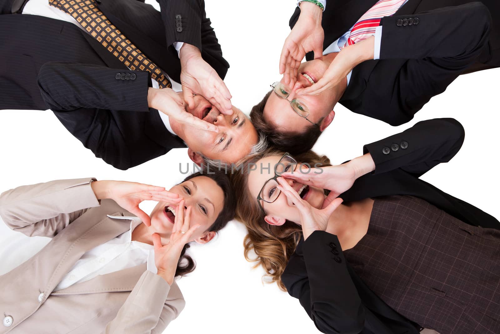 Conceptual image of four businesspeople with their heads together looking directly down at the camera isolated on white