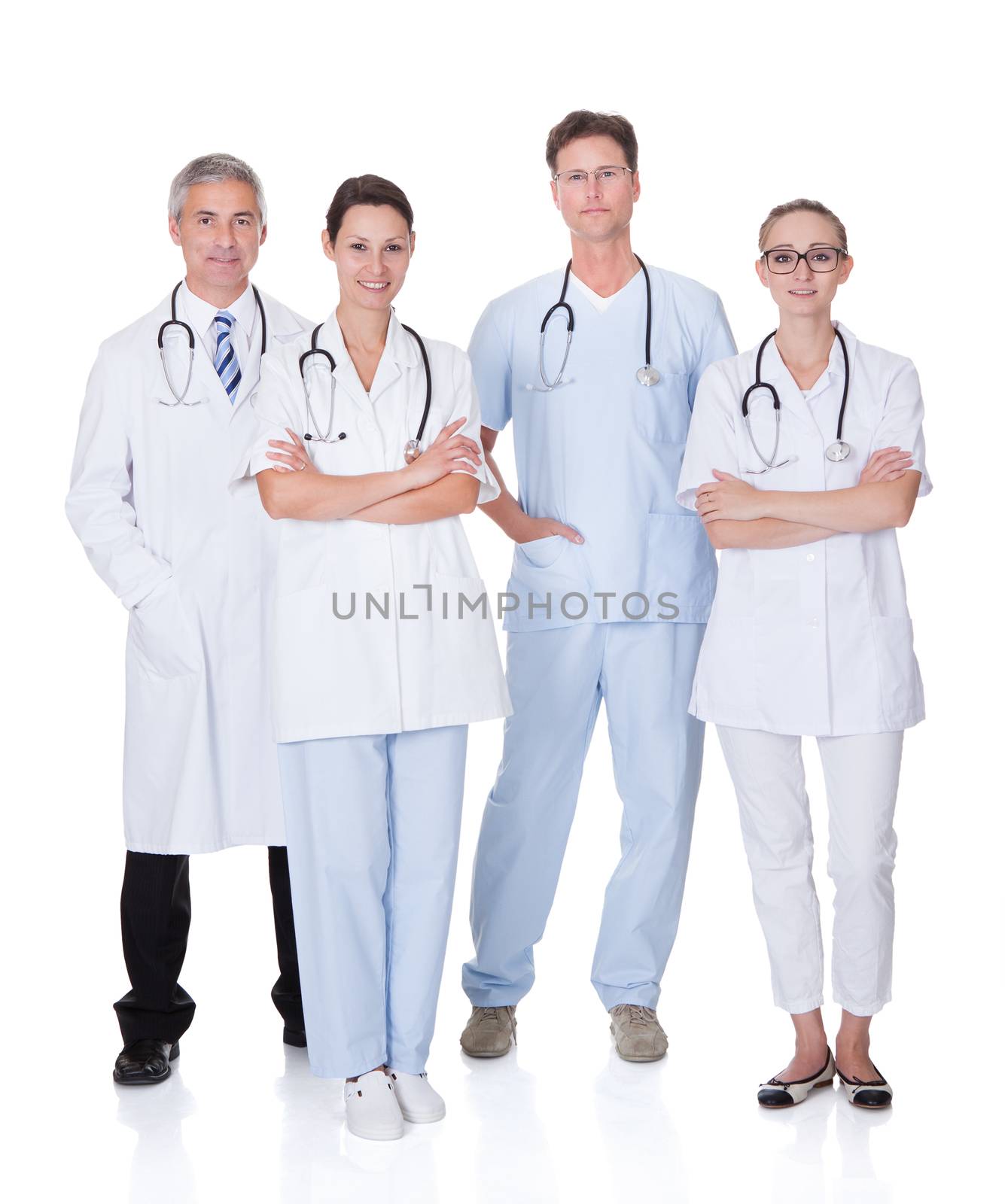 Group of four medical professionals with a male doctor and surgeon and two females doctors on a white studio background