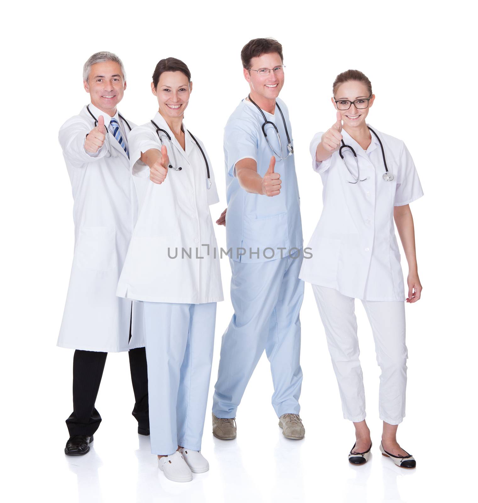 Group of four medical professionals with a male doctor and surgeon and two females doctors on a white studio background