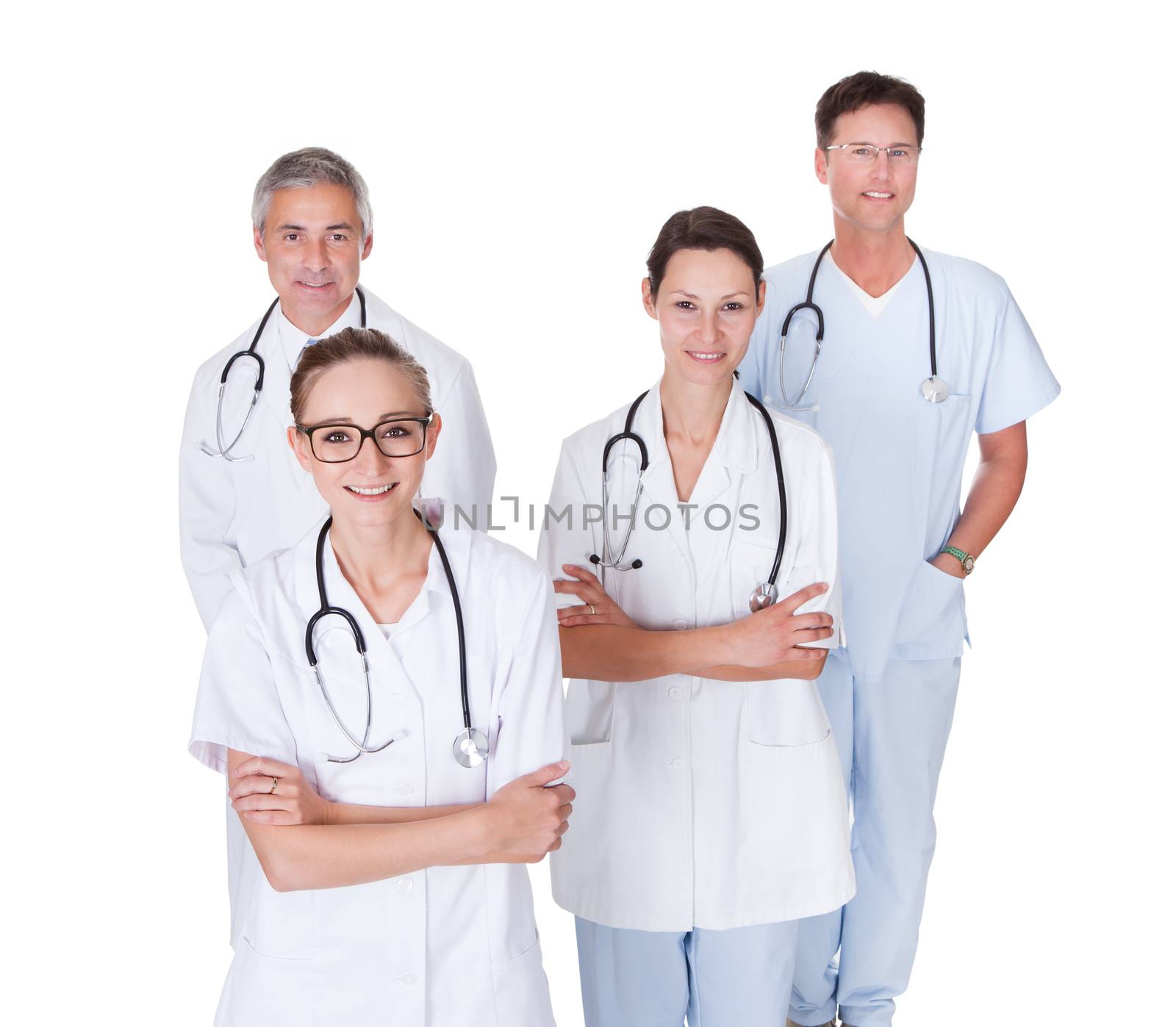 Row of smiling diverse medical doctors and nurses in white uniforms with stethoscopes standing in an oblique receding row isolated on white