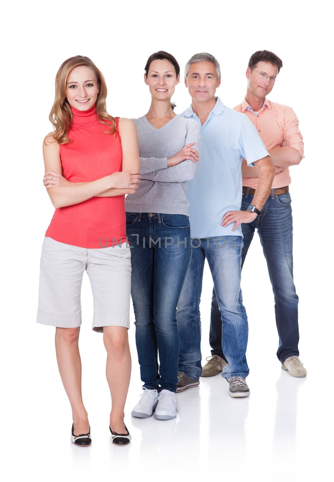 Four middle-aged attractive business associates or friends dressed in casual clothes standing in an oblique line