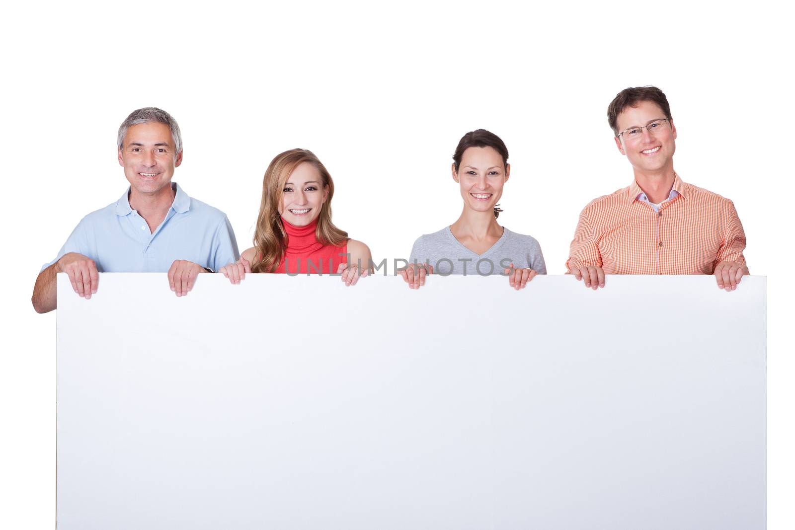 Two happy attractive middle-aged couples in casual clothing holding up a blank horizontal board or banner isolated on white