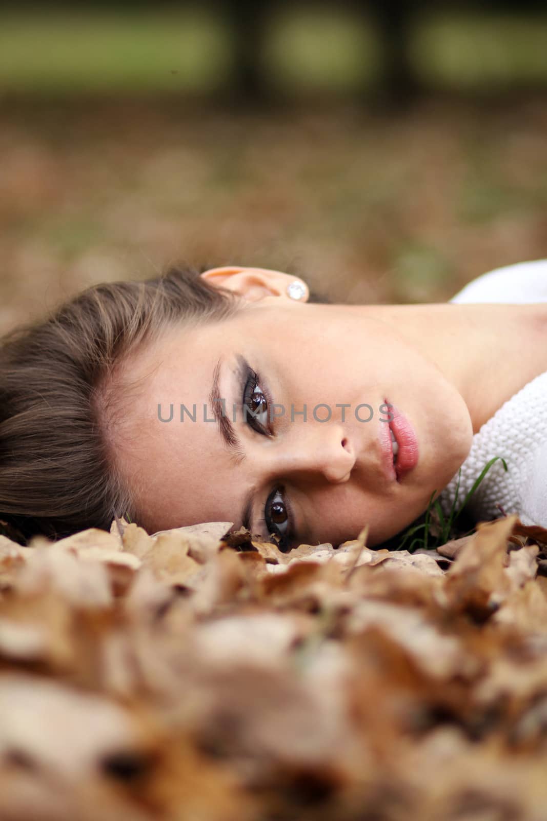 beautiful girl lies on the earth, oak leaves