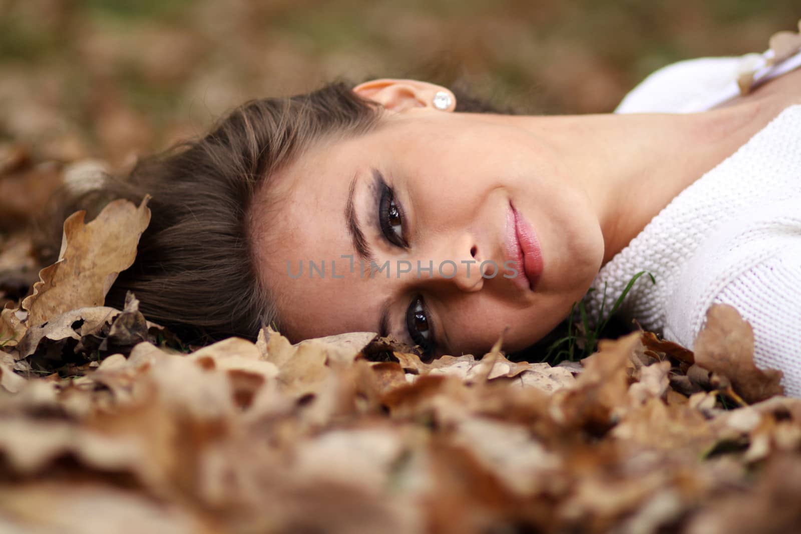 beautiful girl lies on the earth, oak leaves