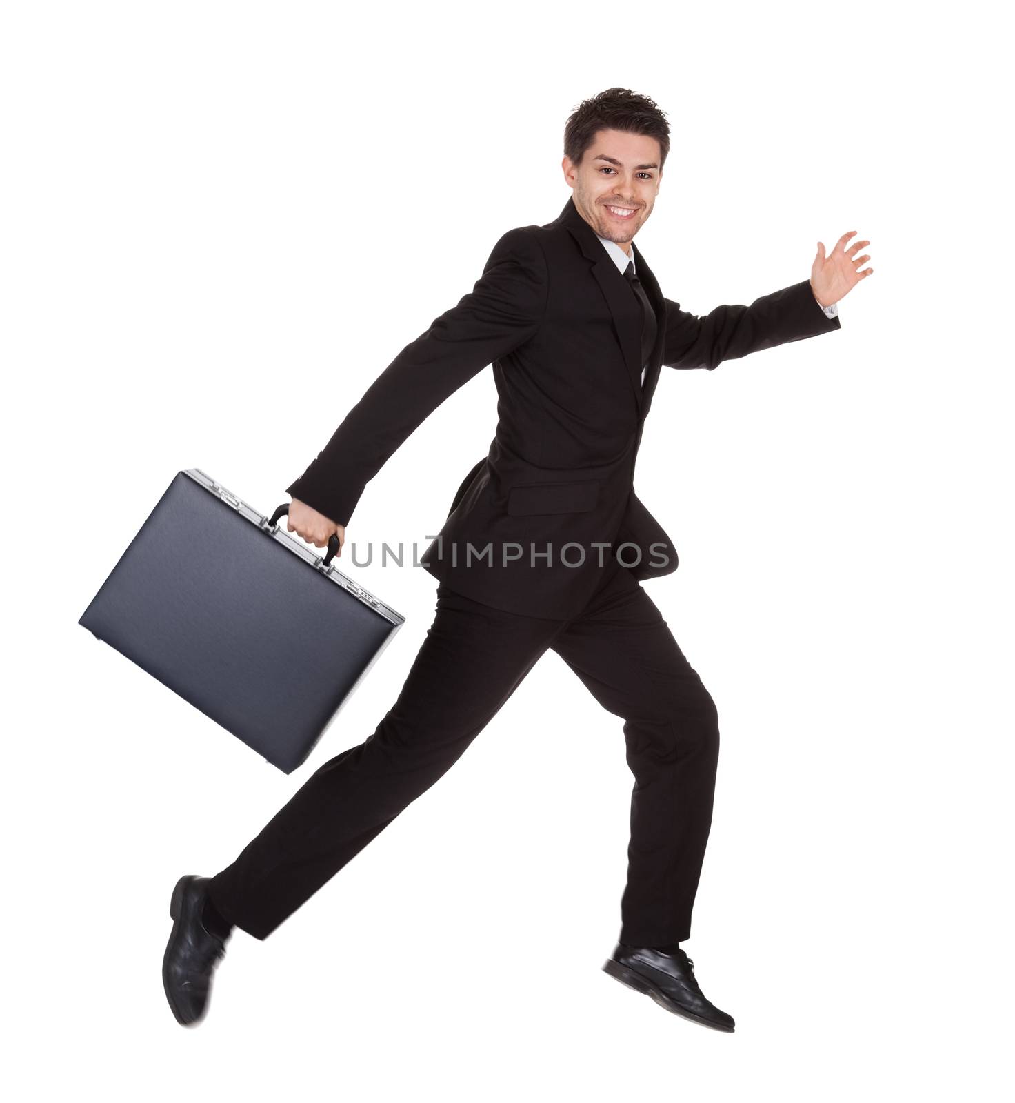 Successful businessman running with his briefcase hurrying along to an appointment full of energy isolated on white