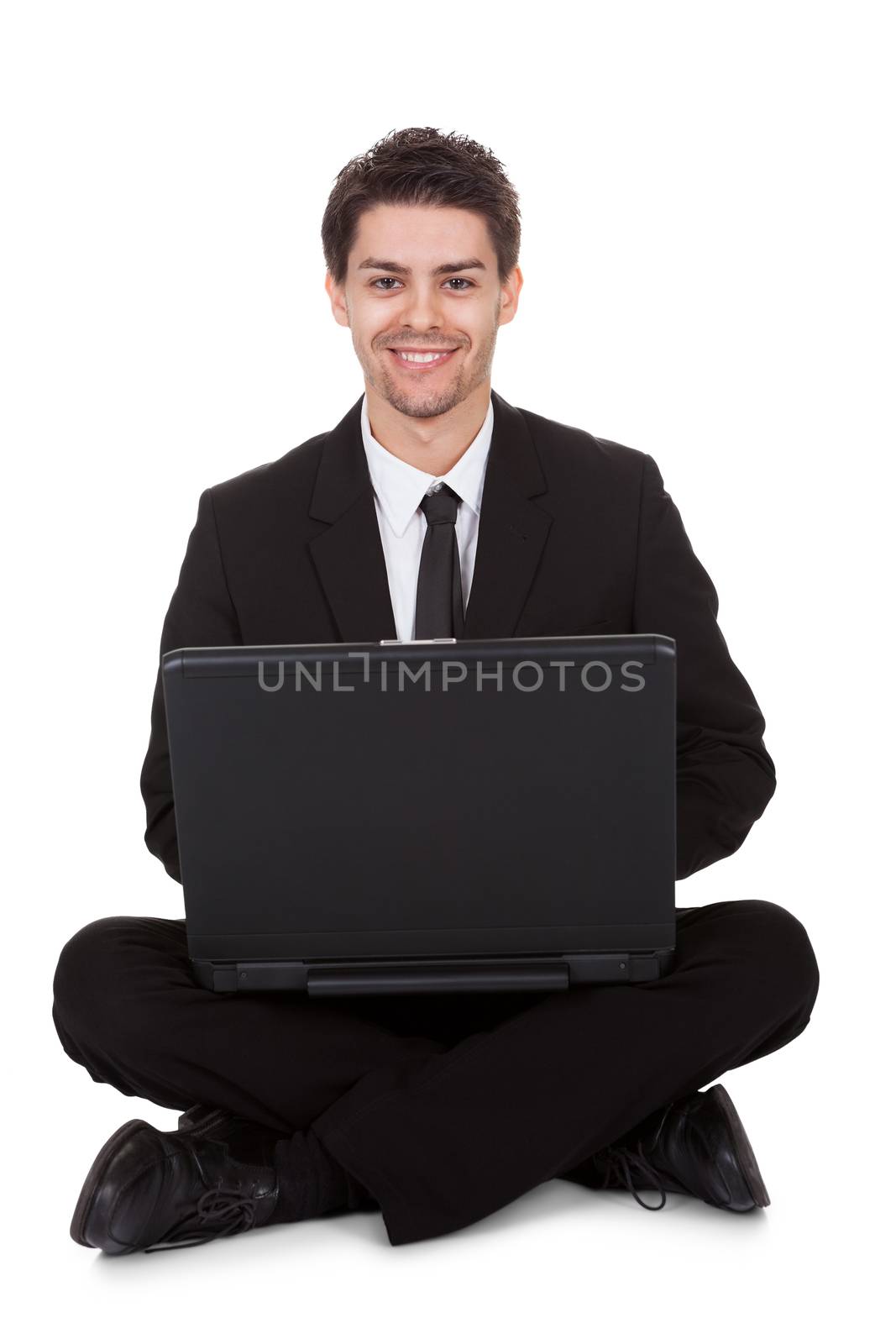 Businessman sitting in yoga pose working on laptop. Isolated on white