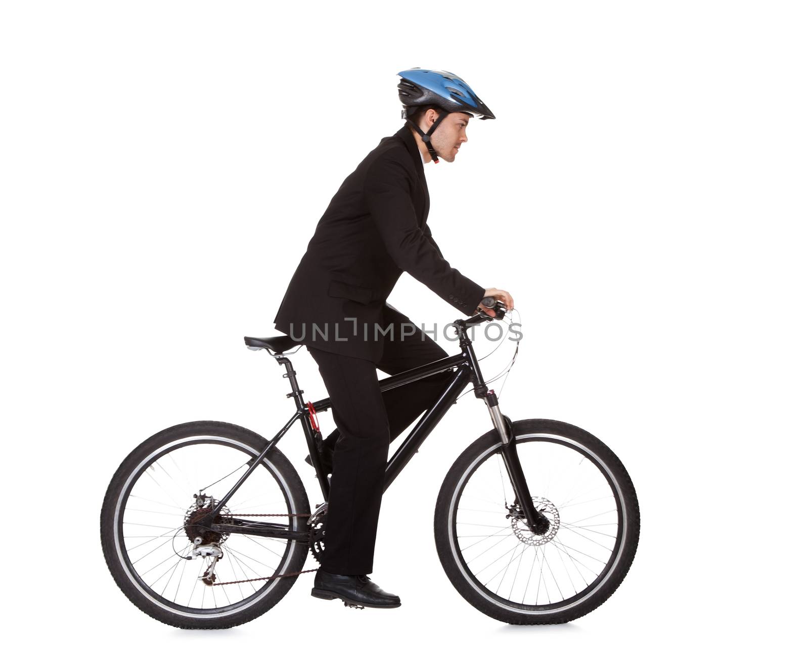 Businessman riding a bicycle to work in his suit exercising for fitness and health and to save on carbon emissions