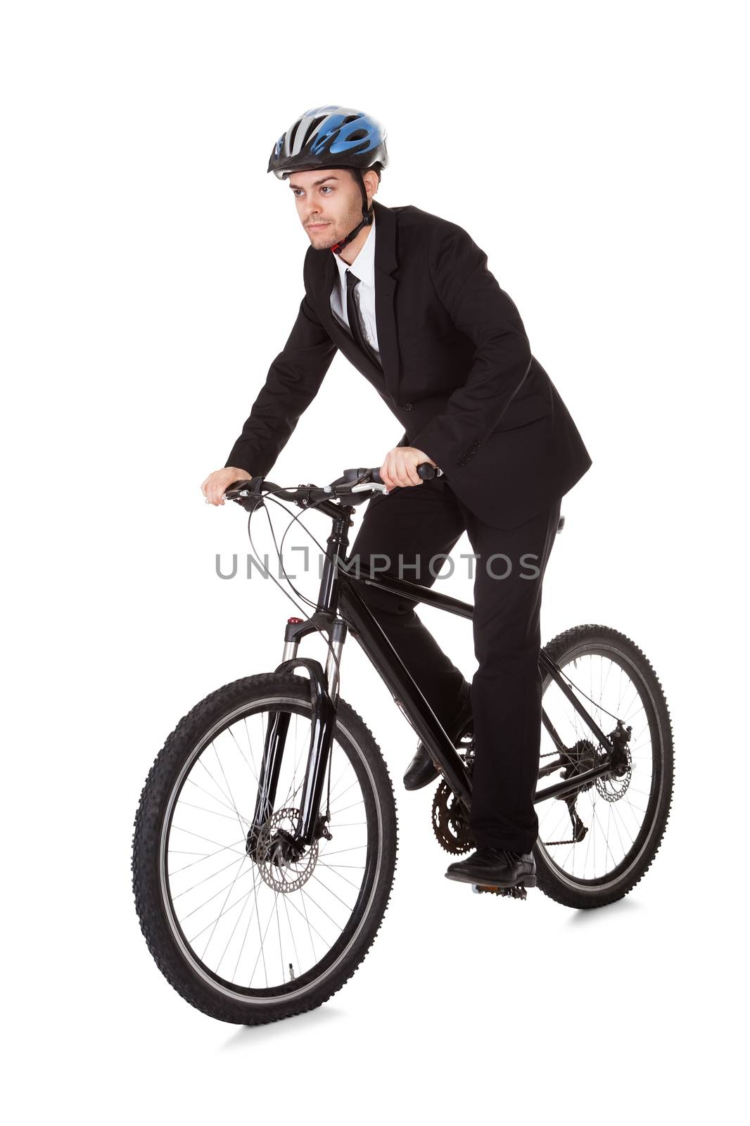 Businessman riding a bicycle to work in his suit exercising for fitness and health and to save on carbon emissions