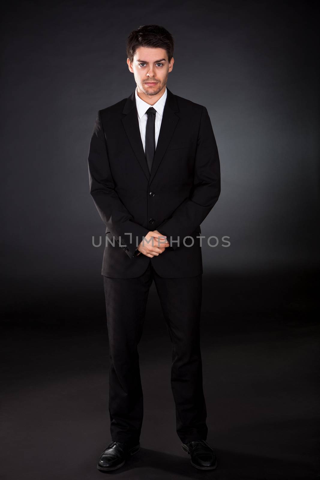 Portrait of smiling businessman over black background