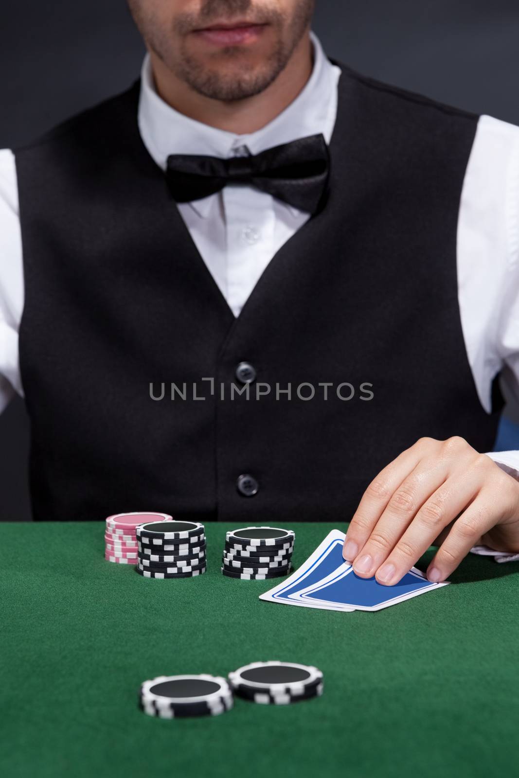 Close-up of a hand of poker player with cards and chips