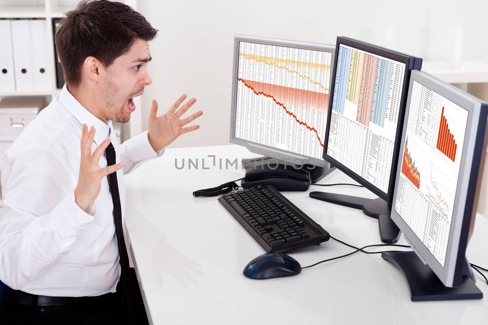 Worried stock broker looking at stock charts going down