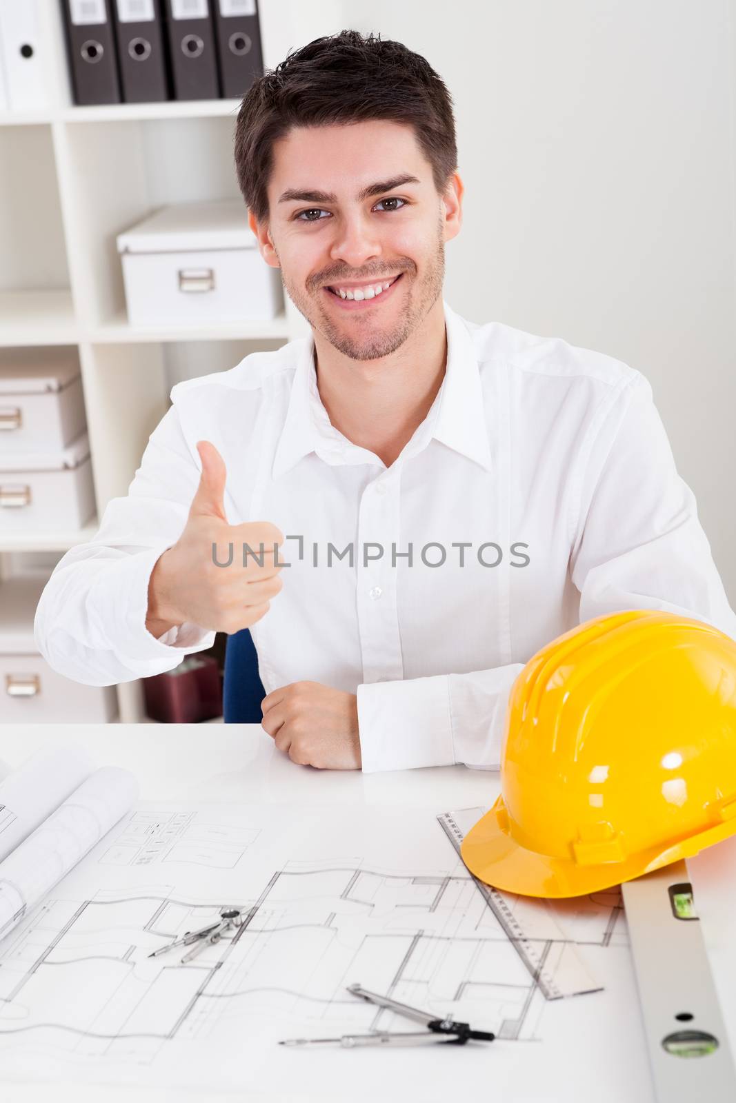 Confident young architect in his office by AndreyPopov