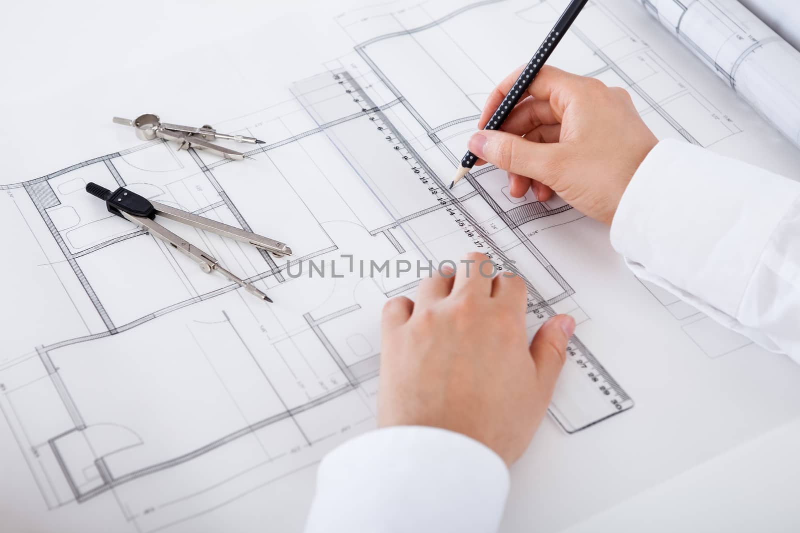 Architect working on blueprints by AndreyPopov