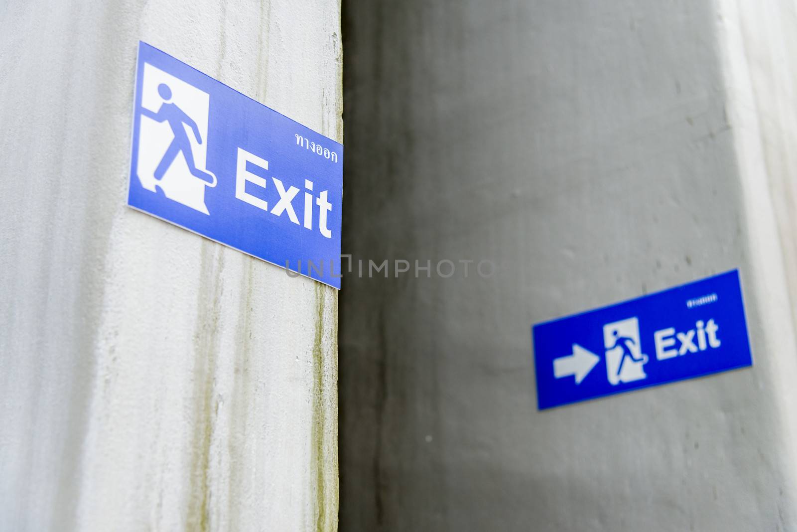 Blue exit sign on white wall2 by gjeerawut