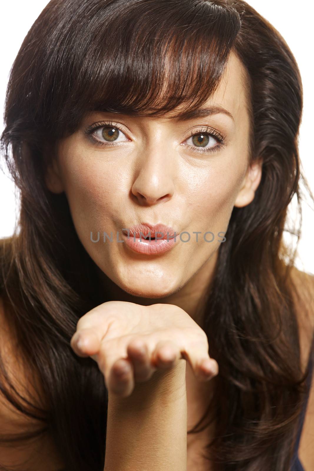 Beautiful young woman blowing a kiss on white background