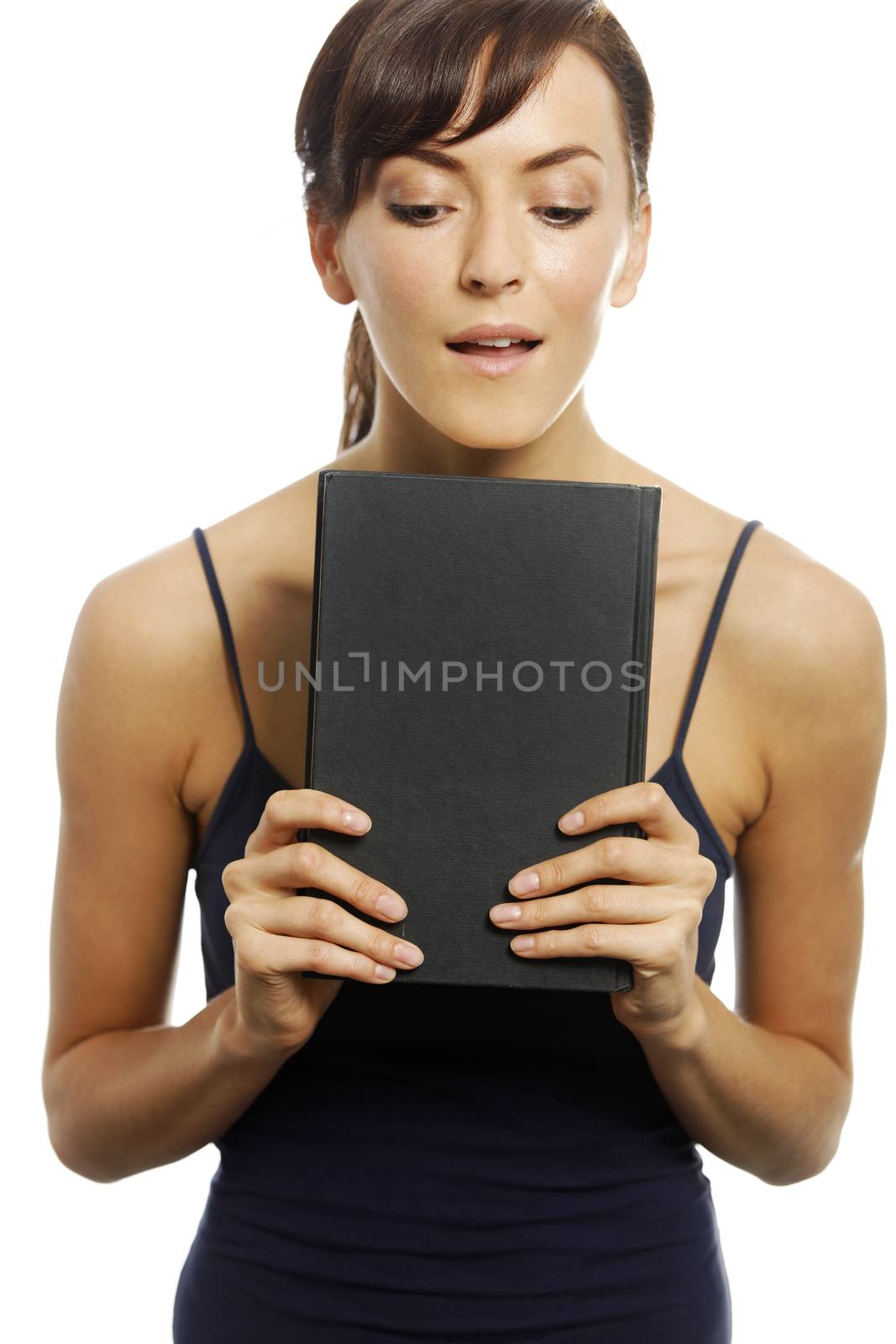 Woman holding a book expressing anticipation.